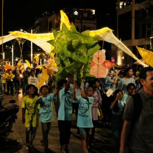 a crowd of people walking down a street at night