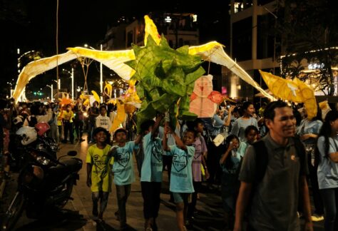 a crowd of people walking down a street at night